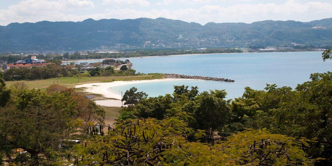 View over Montego Bay, Jamaica, with a white-sand beach, the bay and green hills