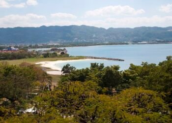 View over Montego Bay, Jamaica, with a white-sand beach, the bay and green hills