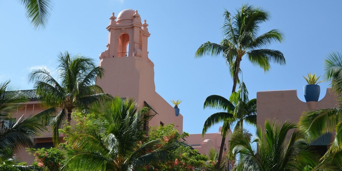 The pink Royal Hawaiian hotel framed by palm trees in Waikiki, Honolulu